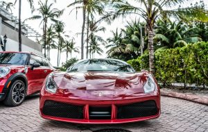 Miami Beach, Florida USA - April 18, 2021: red Ferrari 488 GTB with palms, front view.